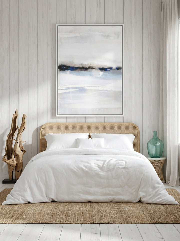 Oversized statement canvas wall art with a white surround styled on the wall in a coastal bedroom