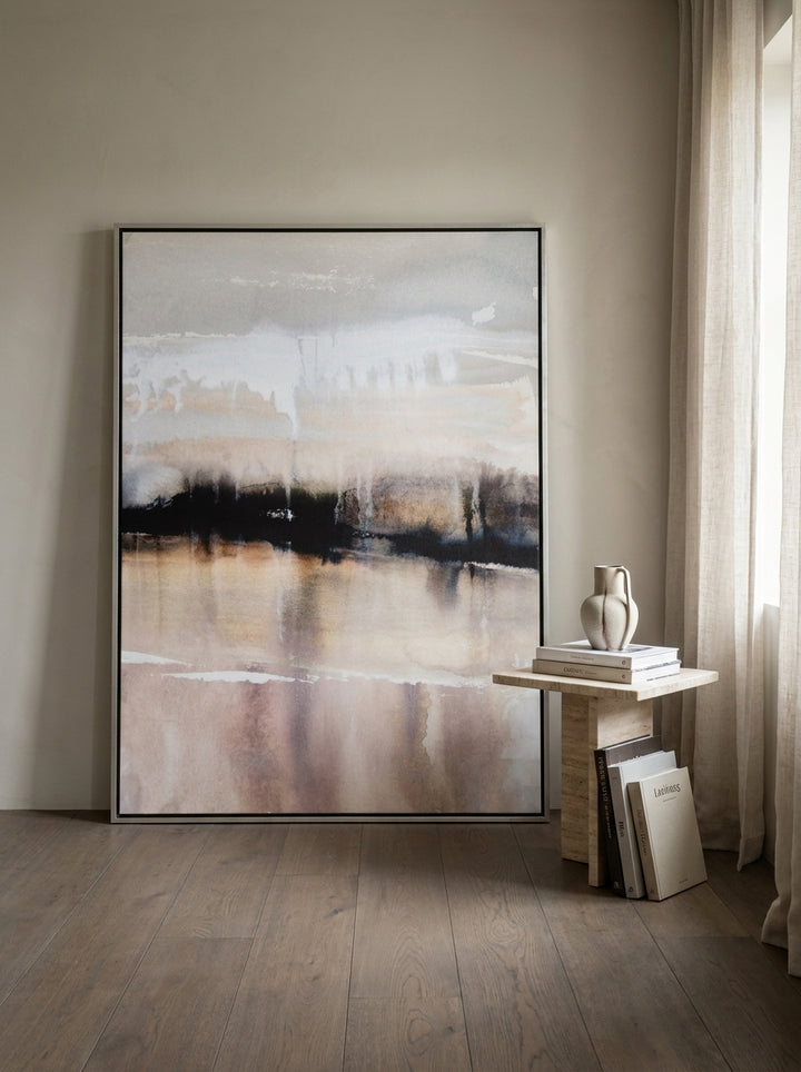Oversized statement canvas wall art with a silver leaf surround leaning against the wall in a luxe bedroom