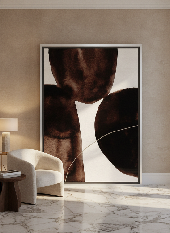 Oversized statement canvas wall art with a silver leaf surround leaning against the wall in a luxe living room
