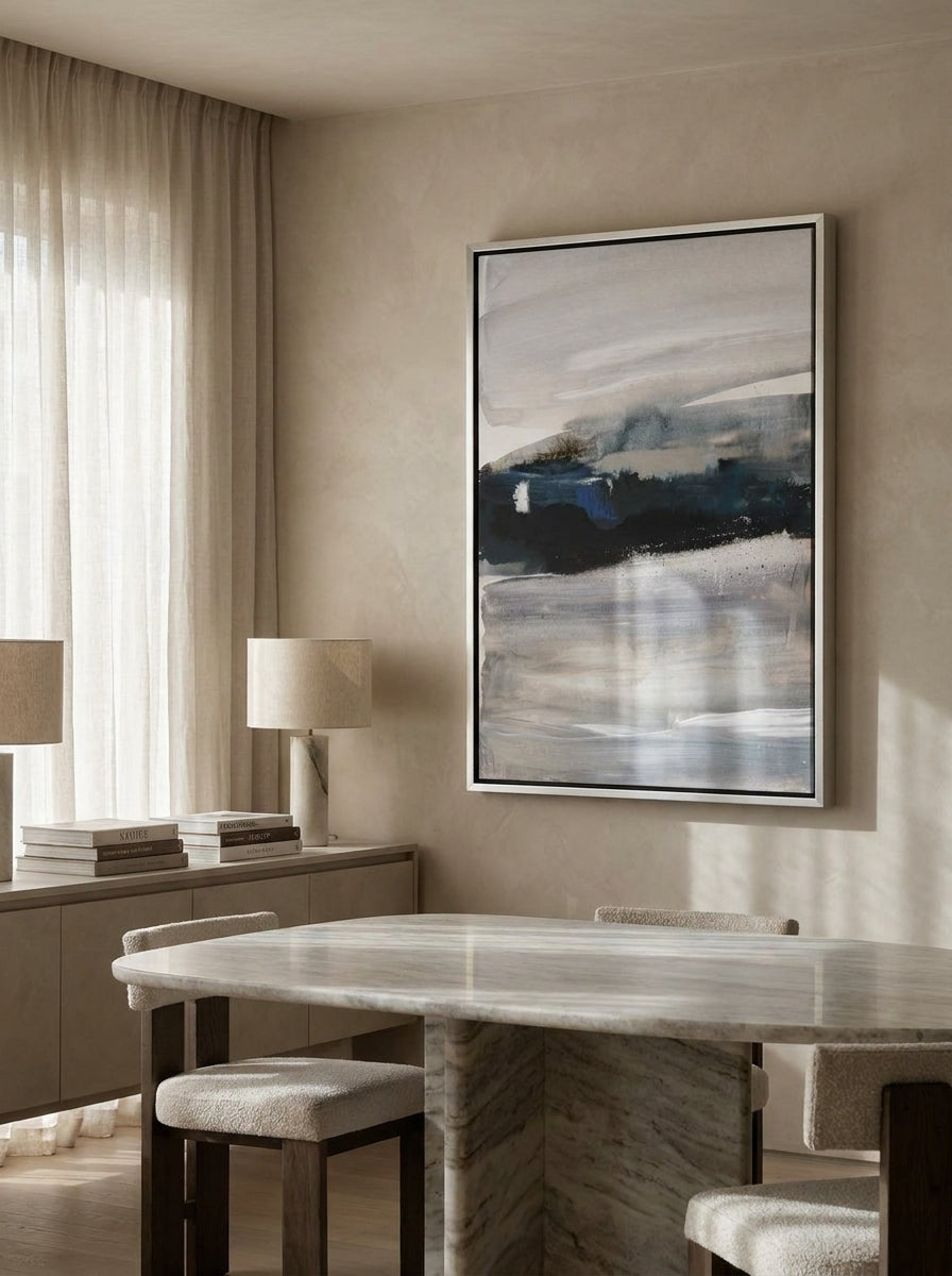 Oversized statement canvas wall art with a silver leaf surround styled on the wall in a luxe dining room