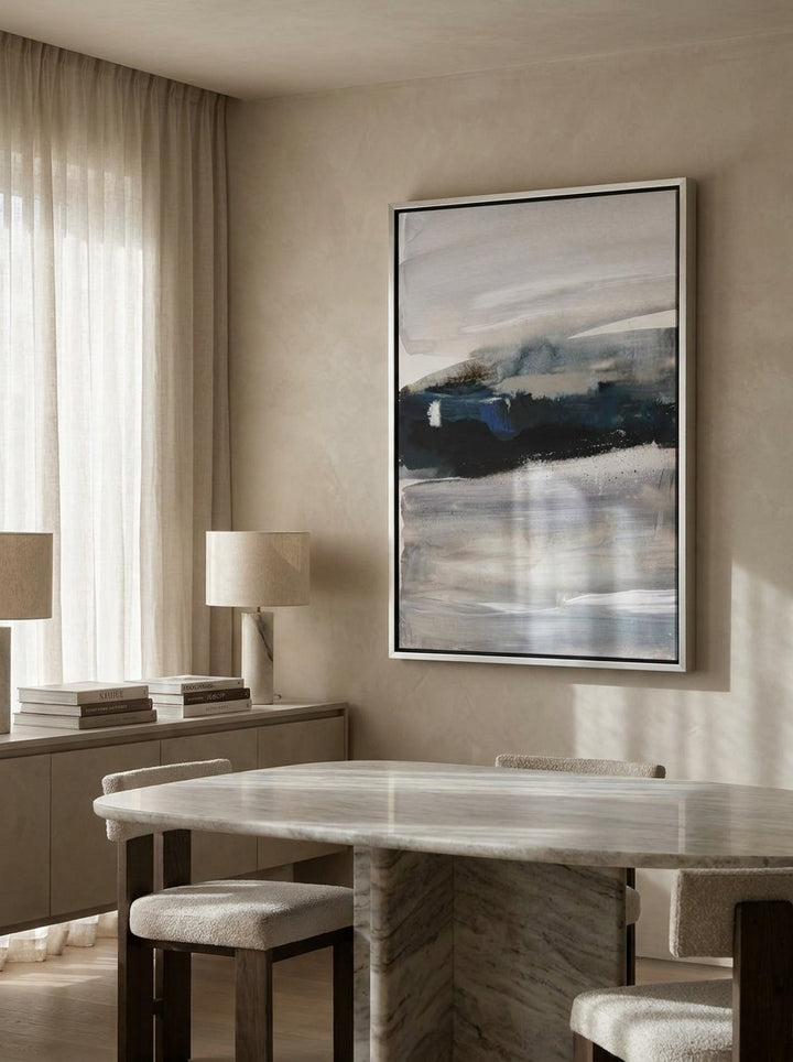 Oversized statement canvas wall art with a silver leaf surround styled on the wall in a luxe dining room