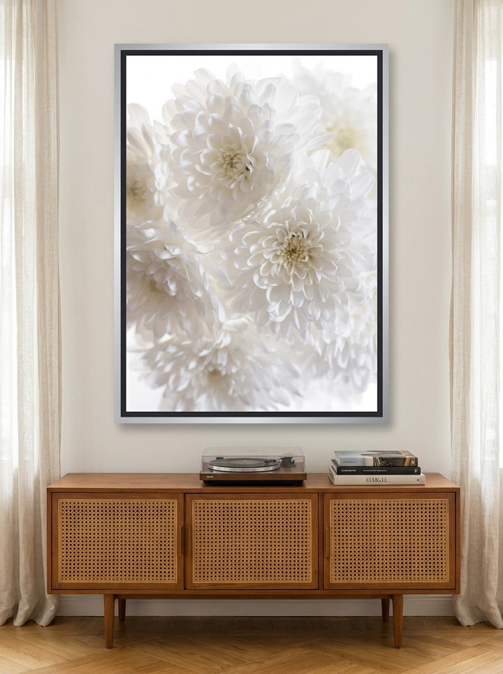 Oversized statement canvas wall art with a silver leaf surround styled on the wall in a mid-century living room