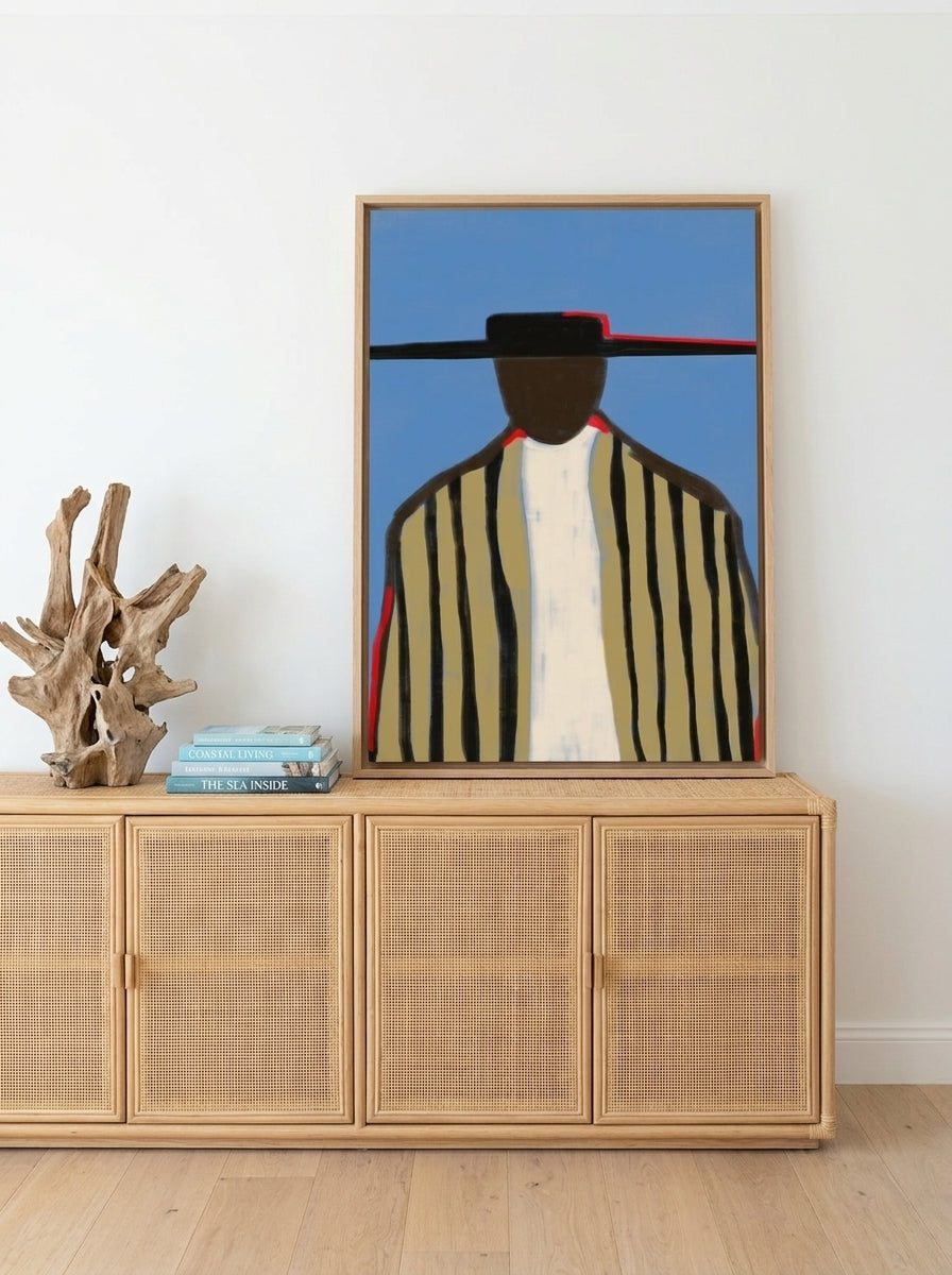 Canvas wall art with a natural timber surround standing on a sideboard in a coastal bedroom