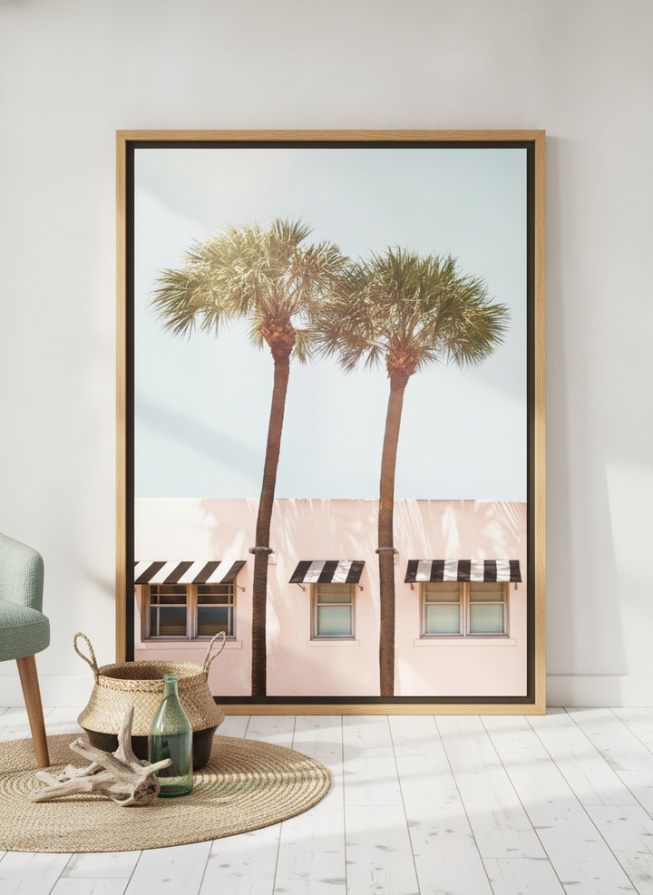 Oversized statement canvas wall art with a natural timber surround leaning against the wall in a coastal dining room