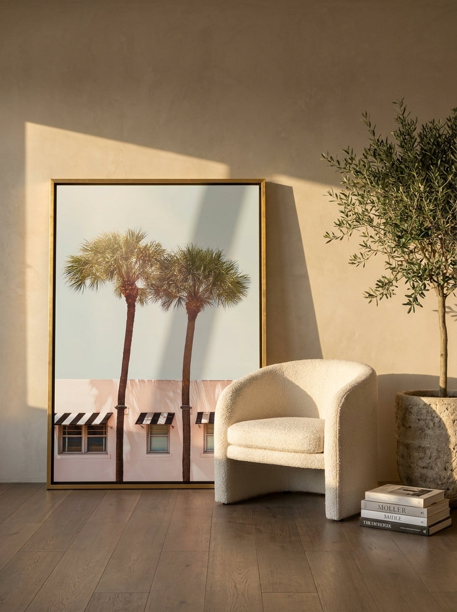 Canvas wall art with a gold leaf surround leaning against the wall in a luxe living room