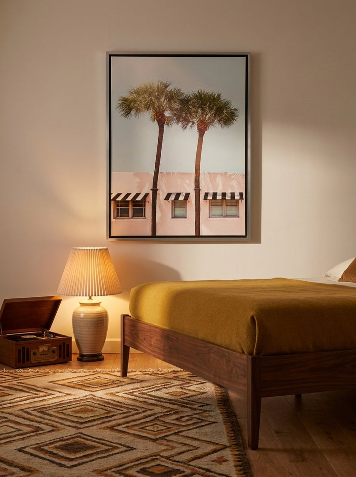 Canvas wall art with a silver leaf surround styled on the wall in a mid-century bedroom