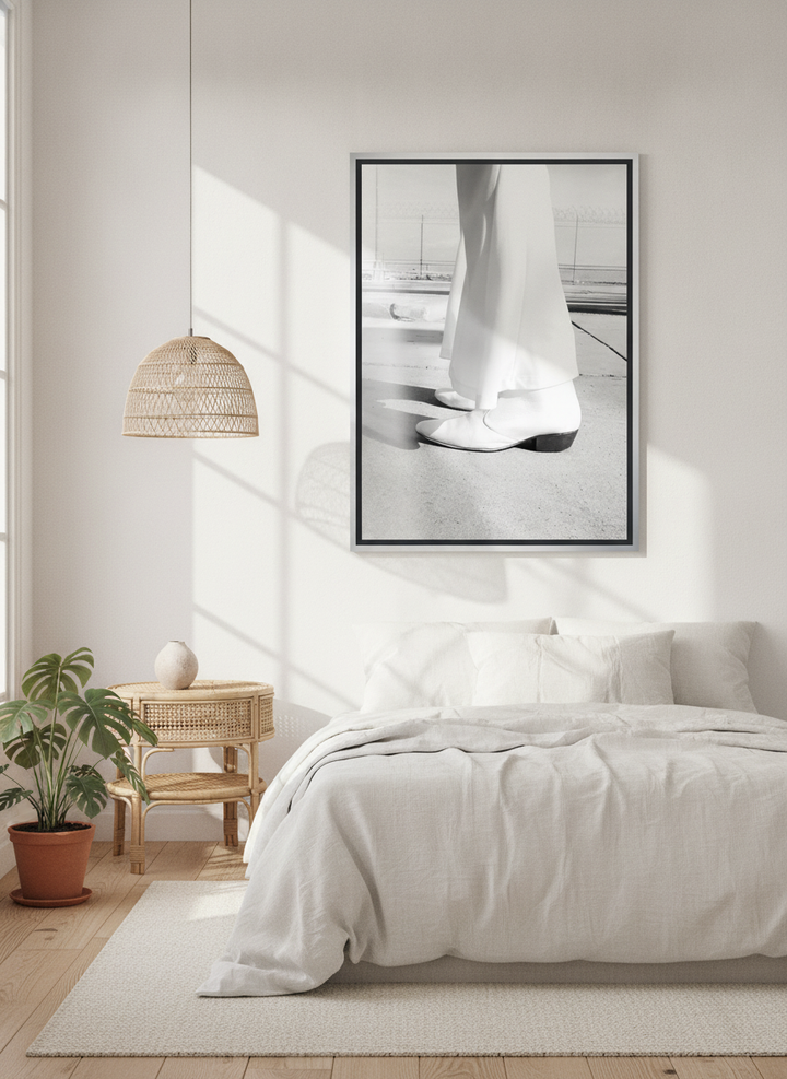 Canvas wall art with a silver leaf surround styled on the wall in a bright Scandinavian bedroom
