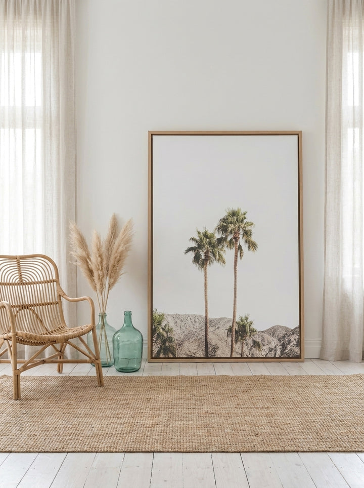 Oversized statement canvas wall art with a natural timber surround leaning against the wall in a coastal dining room