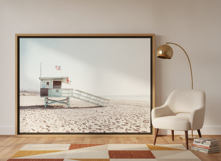 Oversized statement canvas wall art with a natural timber surround leaning against the wall in a mid-century bedroom