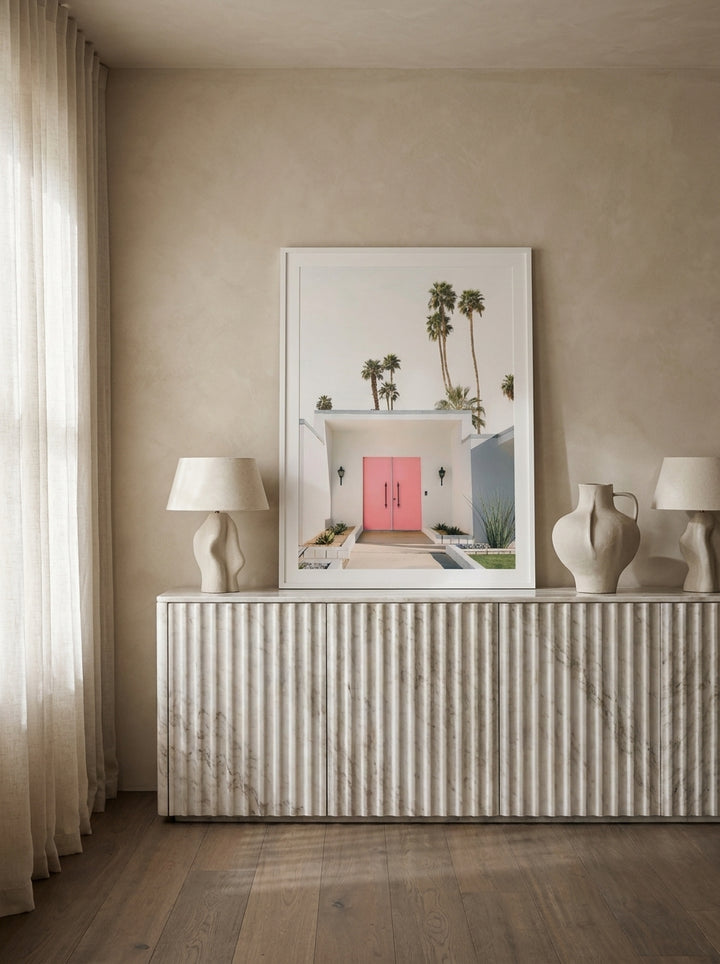 Modern wall art print standing on a sideboard in a luxe bedroom
