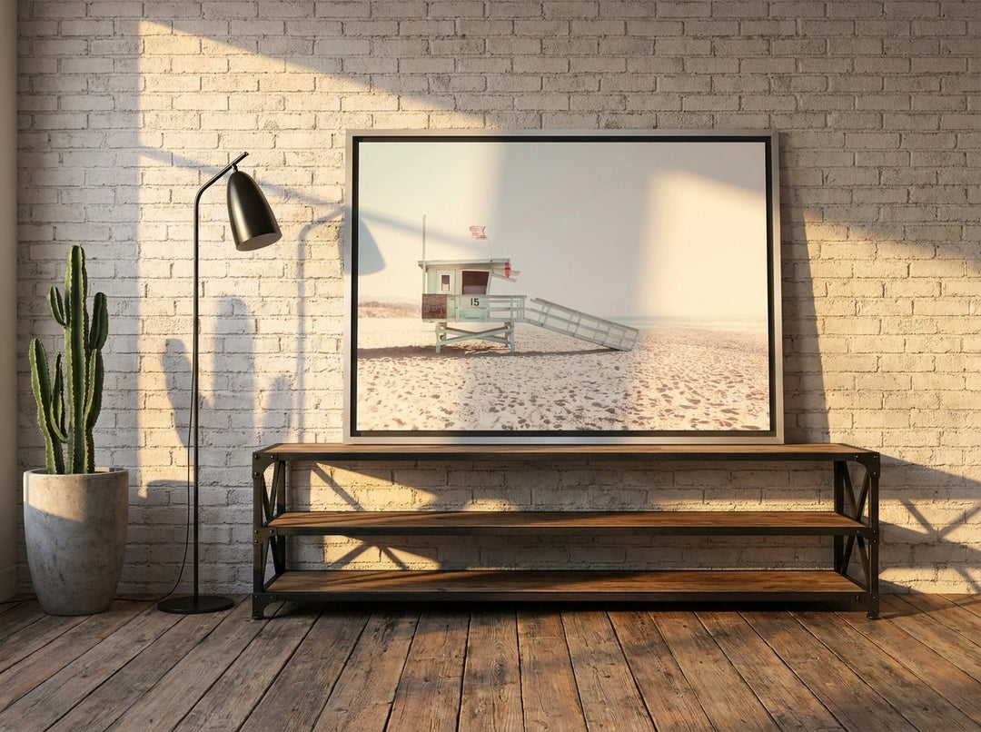 Canvas wall art with a silver leaf surround standing on a console in an industrial loft living room