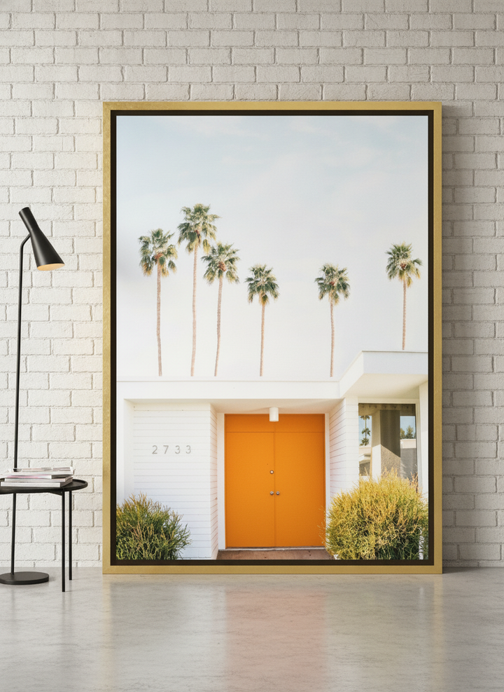 Oversized statement canvas wall art with a gold leaf surround leaning against the wall in an industrial loft living room