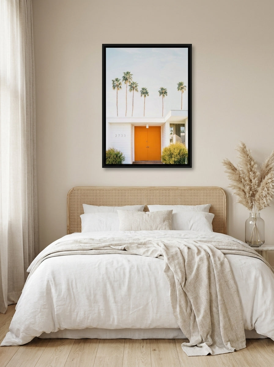 Canvas wall art with a black surround styled on the wall in a coastal bedroom