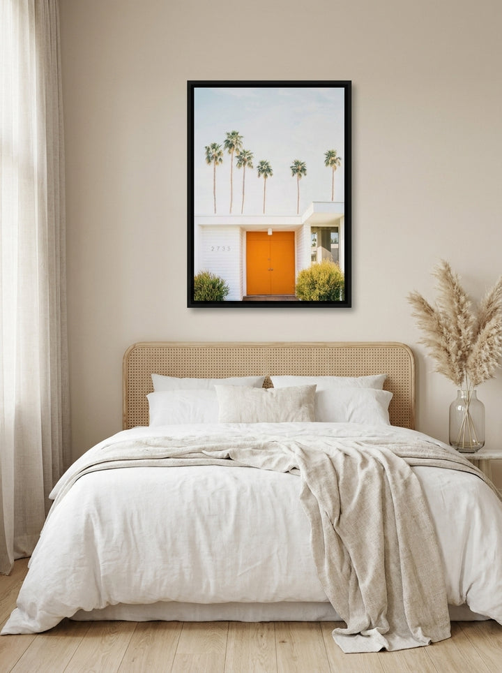 Canvas wall art with a black surround styled on the wall in a coastal bedroom