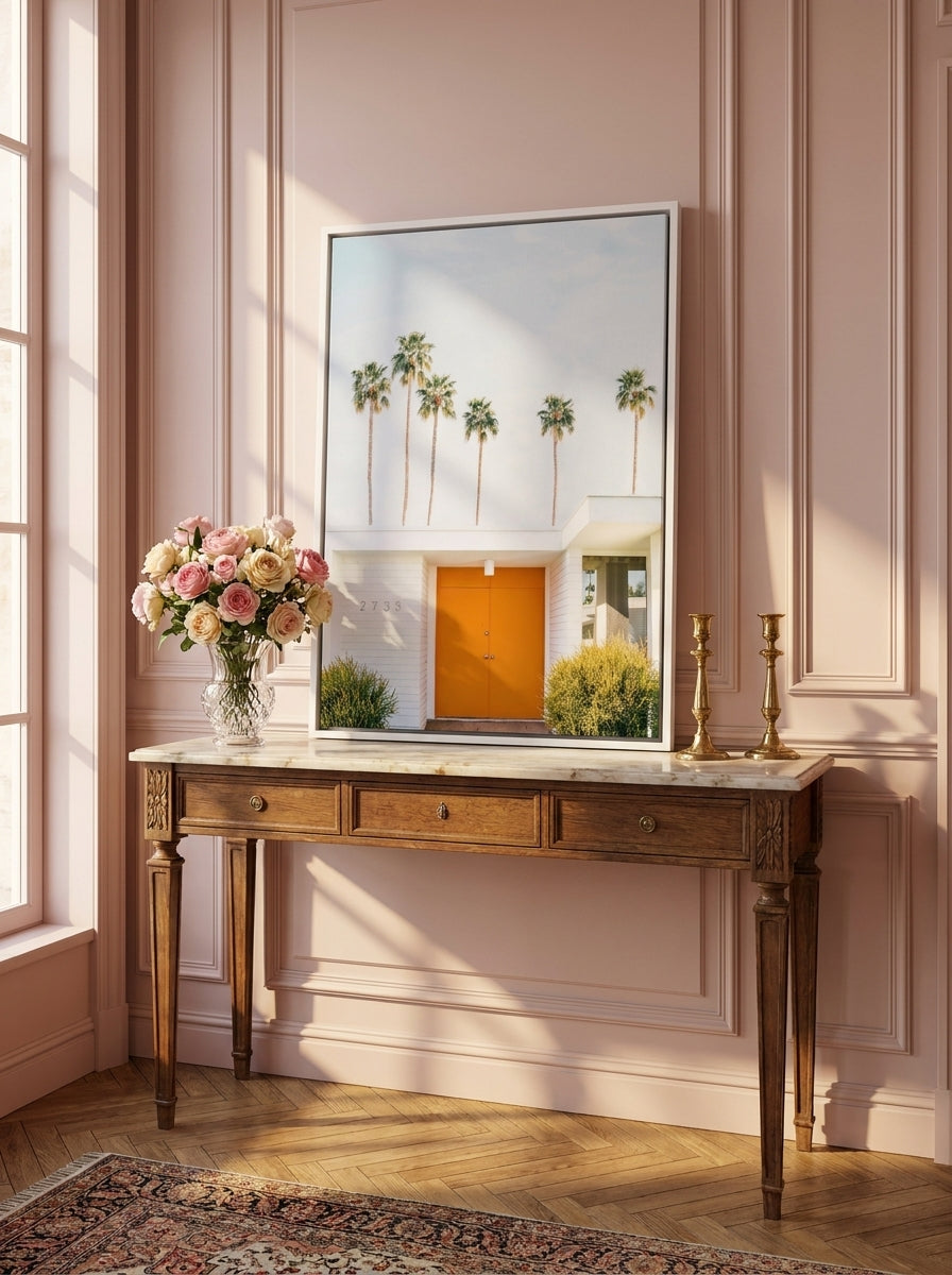 Canvas wall art with a white surround standing on a console in a Parisian bedroom