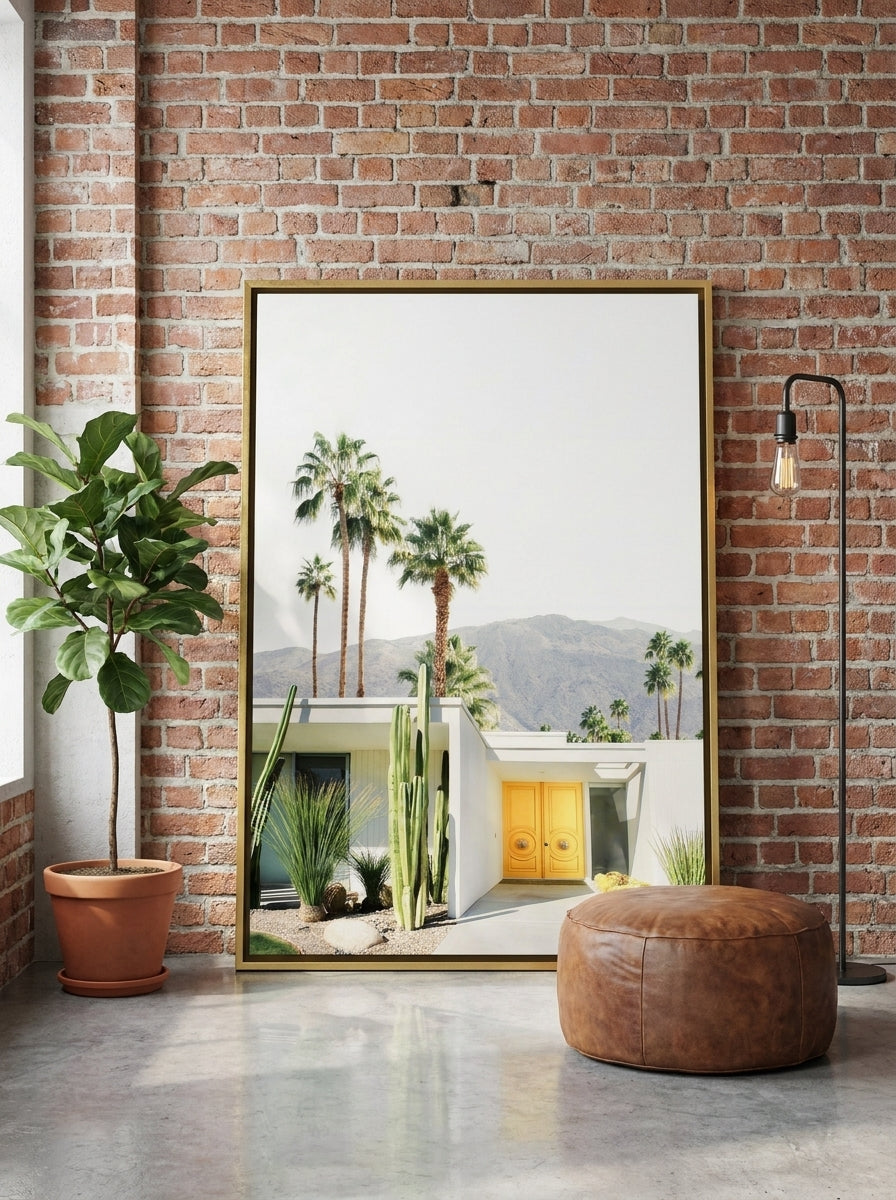 Oversized statement canvas wall art with a gold leaf surround leaning against the wall in an industrial loft living room