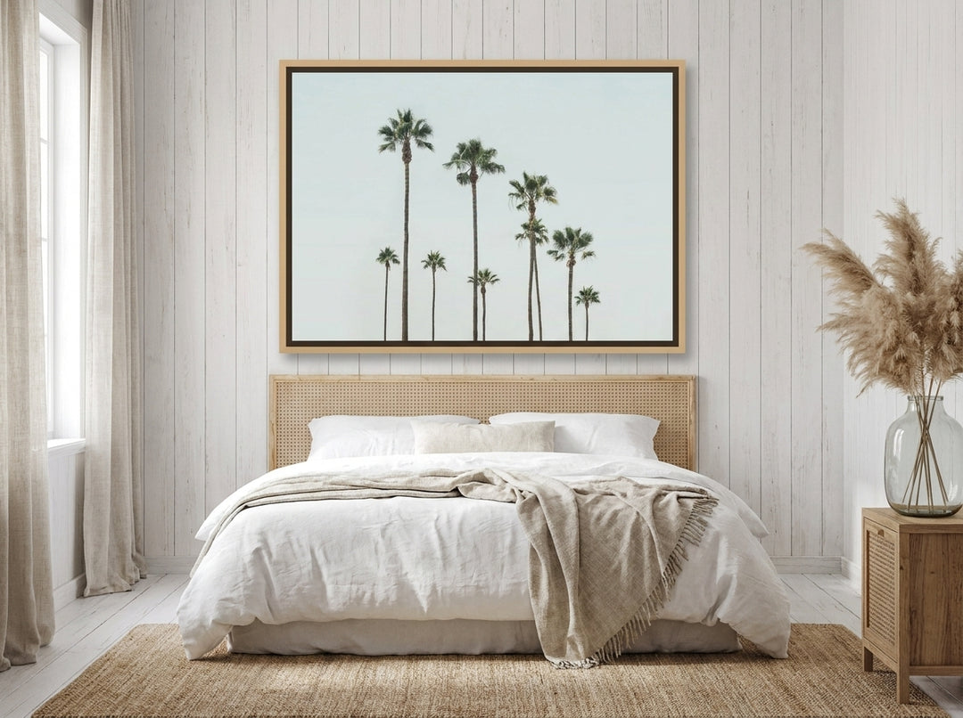 Oversized statement canvas wall art with a natural timber surround styled on the wall in a coastal bedroom
