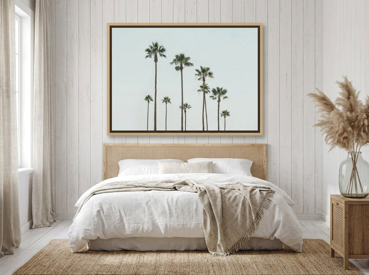 Oversized statement canvas wall art with a natural timber surround styled on the wall in a coastal bedroom