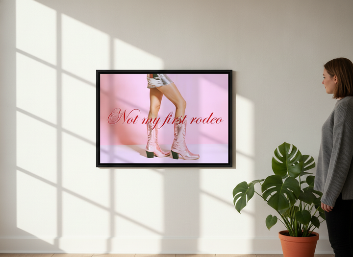 Person holding canvas wall art with a black surround in a bright Scandinavian living room