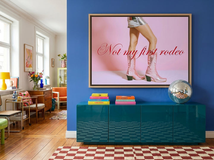 Oversized statement canvas wall art with a natural timber surround styled on the wall in a colourful eclectic living room