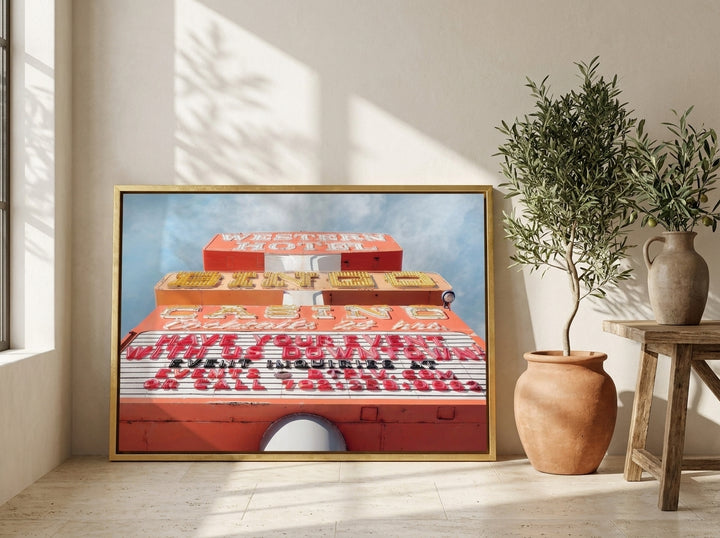 Canvas wall art with a gold leaf surround leaning against the wall in a Mediterranean home office