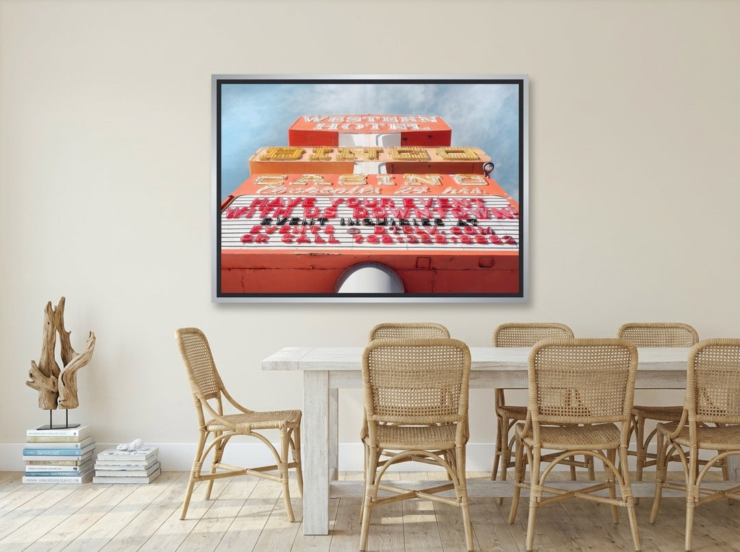 Canvas wall art with a silver leaf surround styled on the wall in a coastal dining room