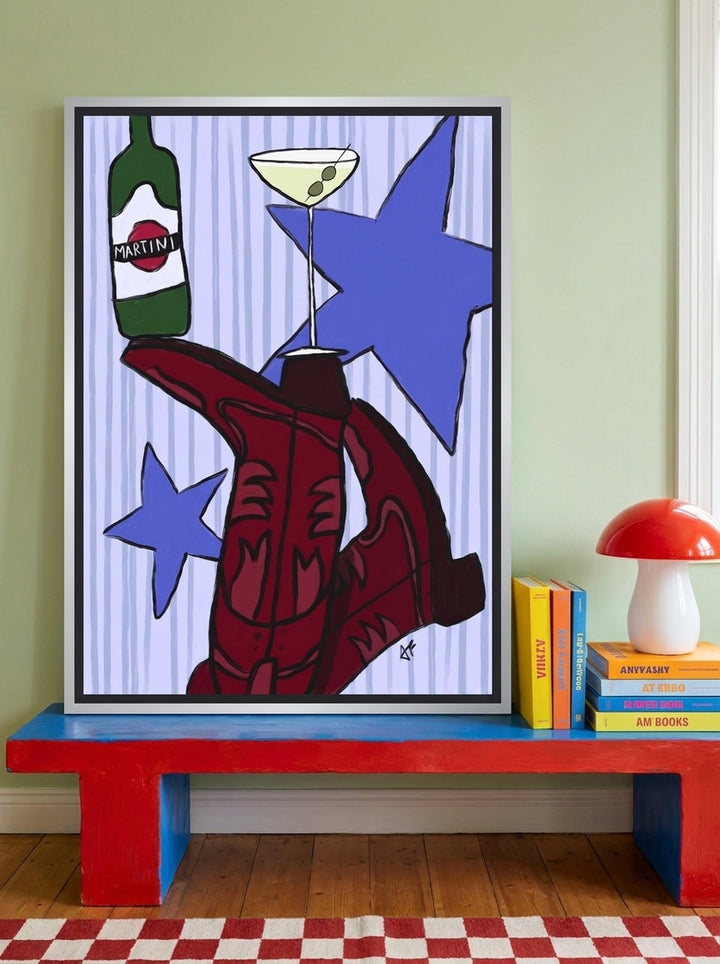 Canvas wall art with a silver leaf surround standing on a side table in a colourful eclectic bedroom