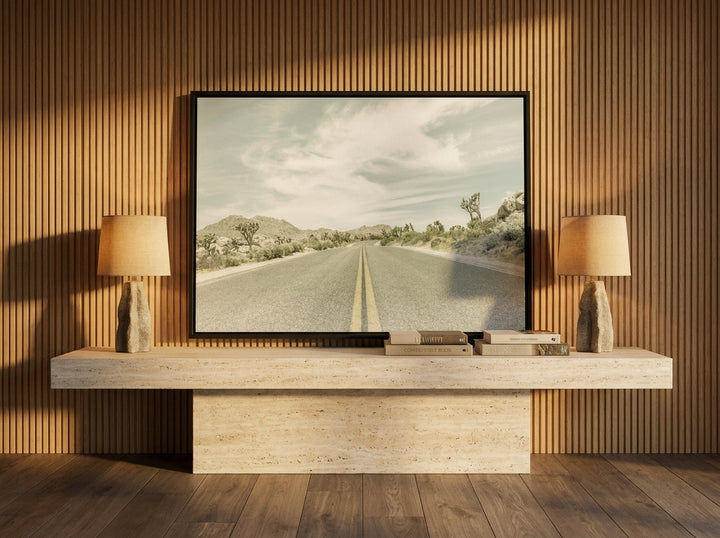 Canvas wall art with a black surround standing on a console in a luxe living room