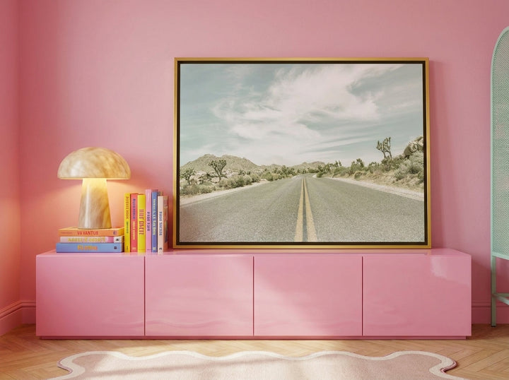 Canvas wall art with a gold leaf surround standing on a sideboard in a colourful eclectic bedroom