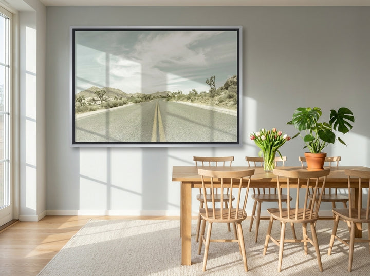 Oversized statement canvas wall art with a silver leaf surround styled on the wall in a bright Scandinavian dining room