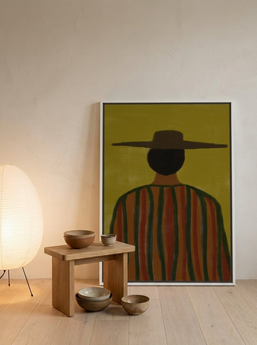 Canvas wall art with a white surround leaning against the wall in a warm Japandi bedroom