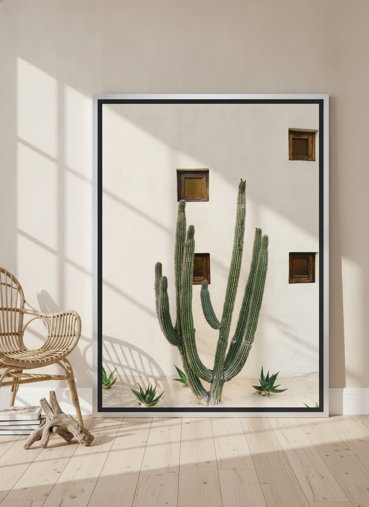 Oversized statement canvas wall art with a silver leaf surround leaning against the wall in a coastal bedroom