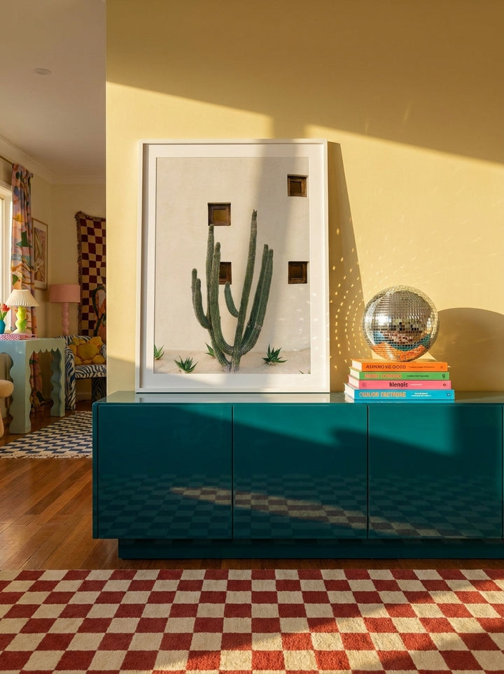 Modern wall art print standing on a sideboard in a colourful eclectic bedroom