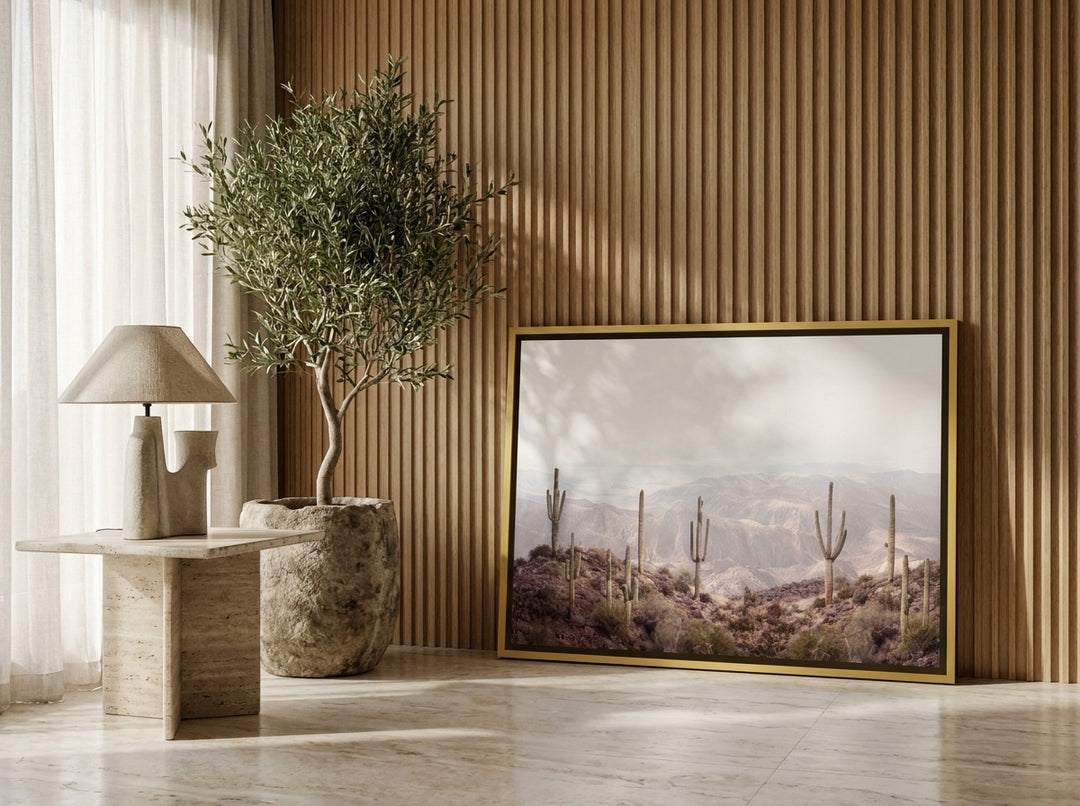 Canvas wall art with a gold leaf surround leaning against the wall in a luxe home office
