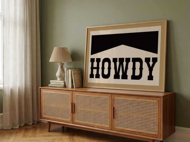 Modern wall art print standing on a sideboard in a mid-century home office