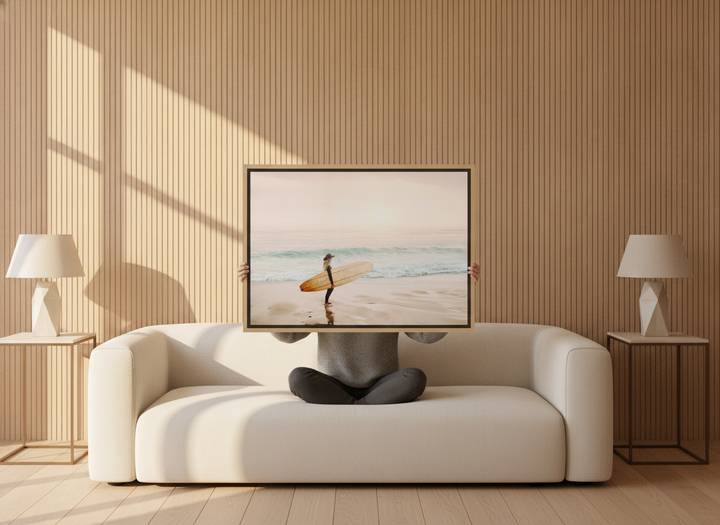 Person holding canvas wall art with a natural timber surround in a luxe living room