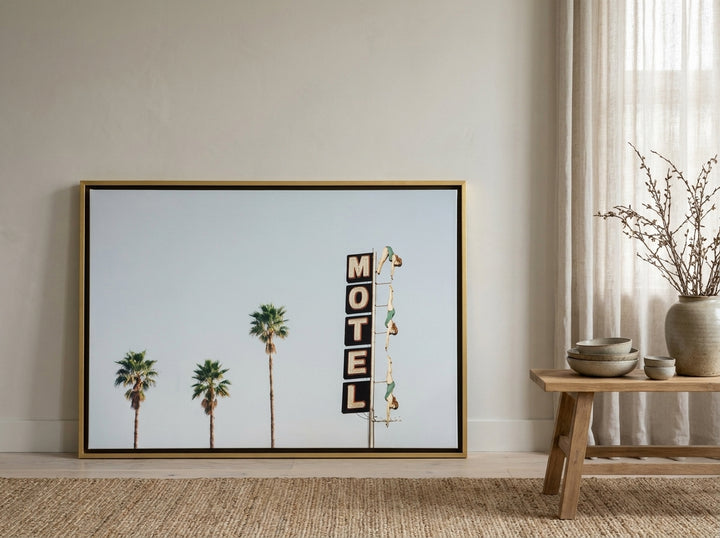 Canvas wall art with a gold leaf surround leaning against the wall in a warm Japandi living room
