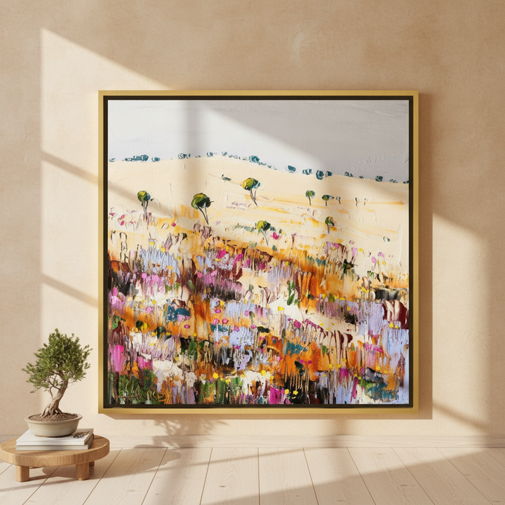Oversized statement canvas wall art with a gold leaf surround leaning against the wall in a warm Japandi living room