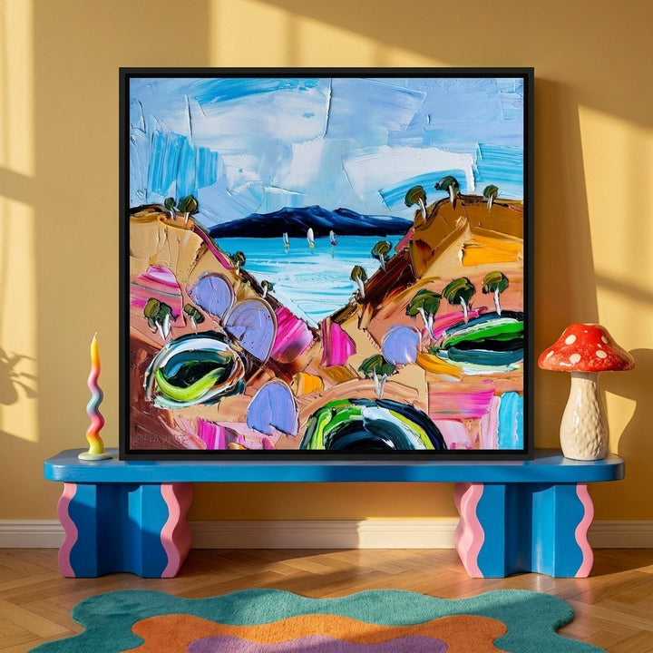 Canvas wall art with a black surround standing on a side table in a colourful eclectic bedroom
