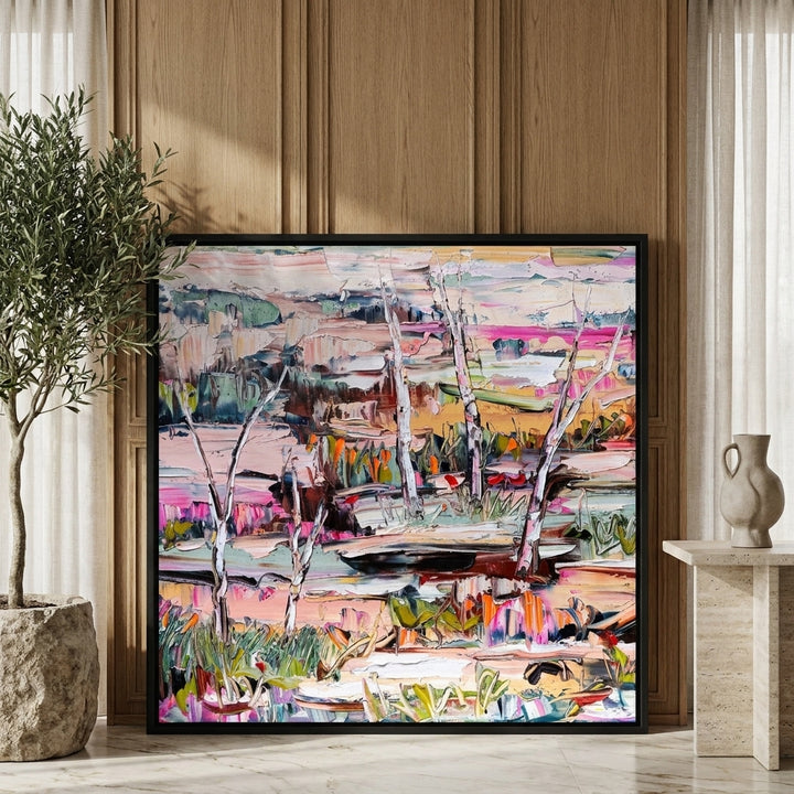 Canvas wall art with a black surround leaning against the wall in a luxe bedroom