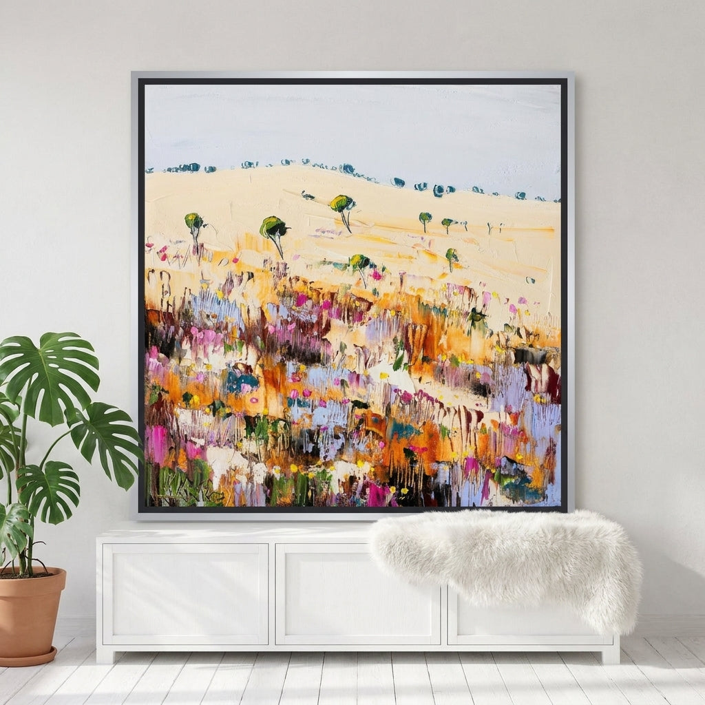 Canvas wall art with a silver leaf surround standing on a sideboard in a bright Scandinavian dining room