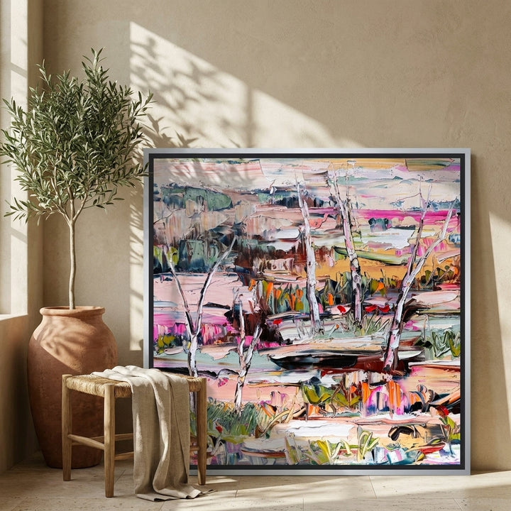 Canvas wall art with a silver leaf surround leaning against the wall in a Mediterranean living room
