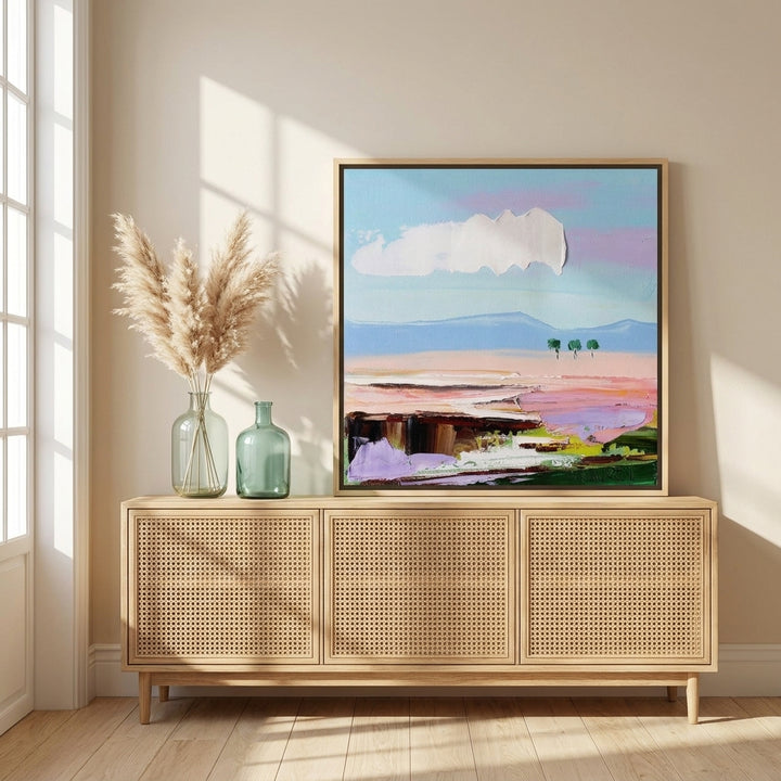Canvas wall art with a natural timber surround standing on a sideboard in a coastal bedroom