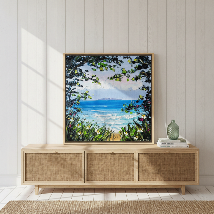 Canvas wall art with a natural timber surround standing on a sideboard in a coastal bedroom