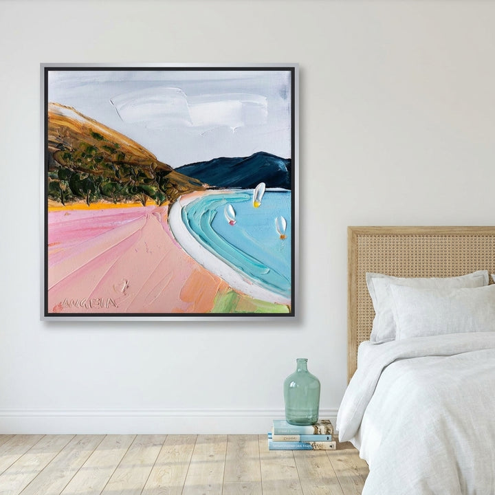 Canvas wall art with a silver leaf surround styled on the wall in a coastal bedroom