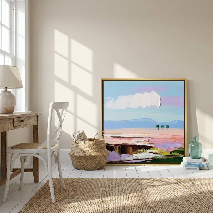 Canvas wall art with a gold leaf surround leaning against the wall in a coastal dining room