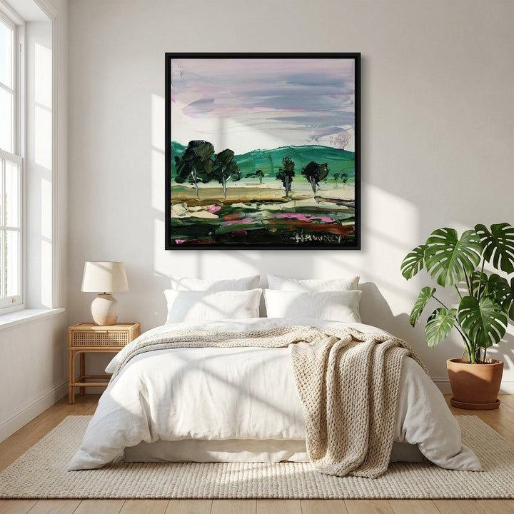 Canvas wall art with a black surround styled on the wall in a bright Scandinavian bedroom