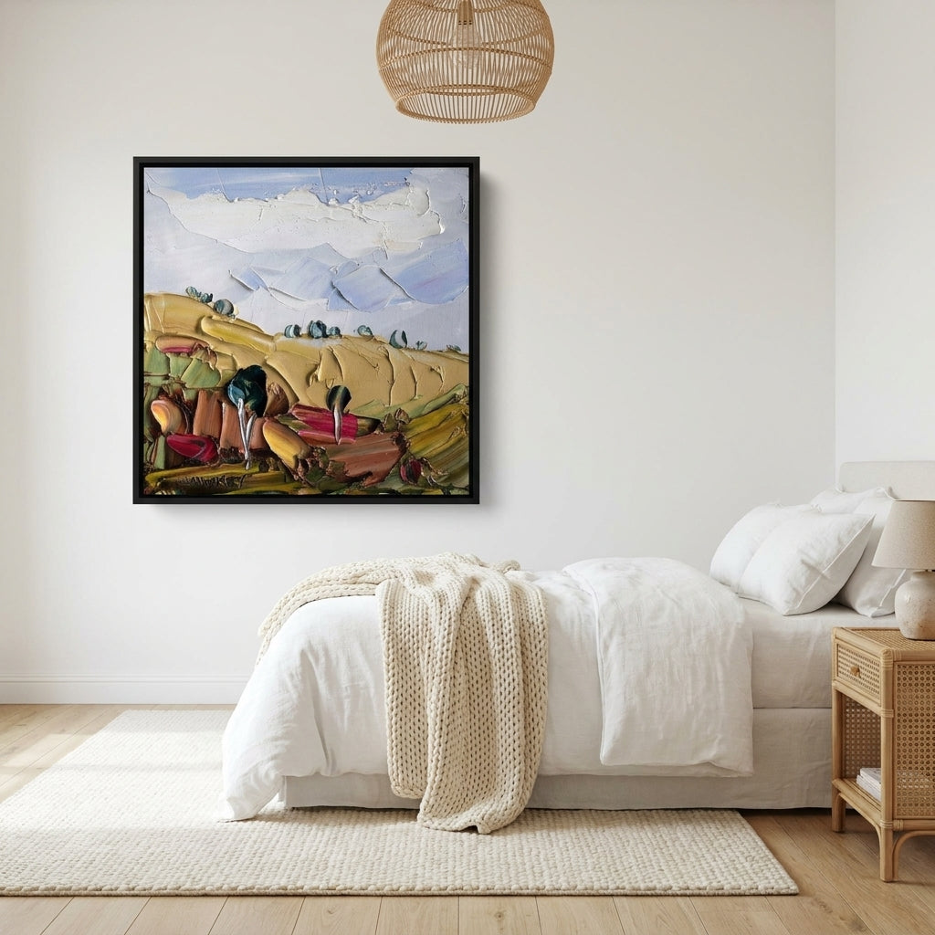 Canvas wall art with a black surround styled on the wall in a bright Scandinavian bedroom