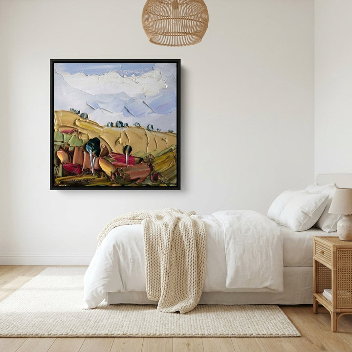 Canvas wall art with a black surround styled on the wall in a bright Scandinavian bedroom