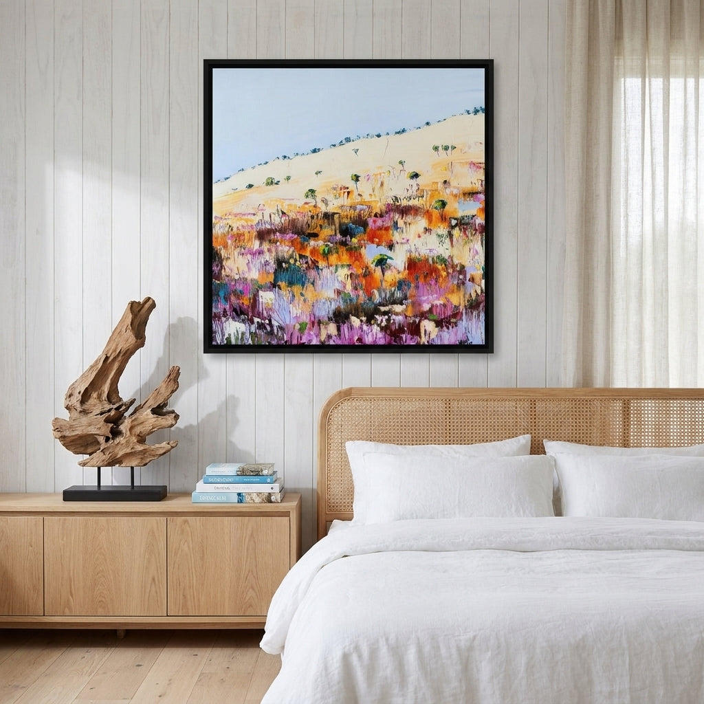Canvas wall art with a black surround styled on the wall in a coastal bedroom